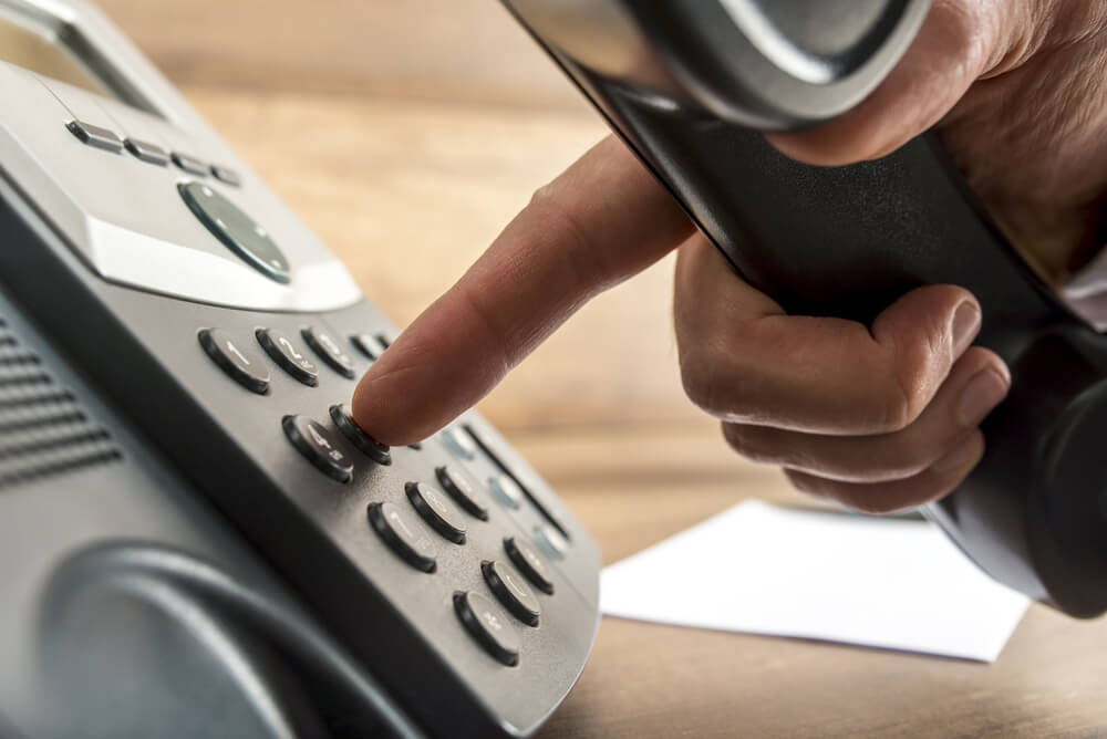 mao masculina apertando botao de telefone ao iniciar venda por telefone 